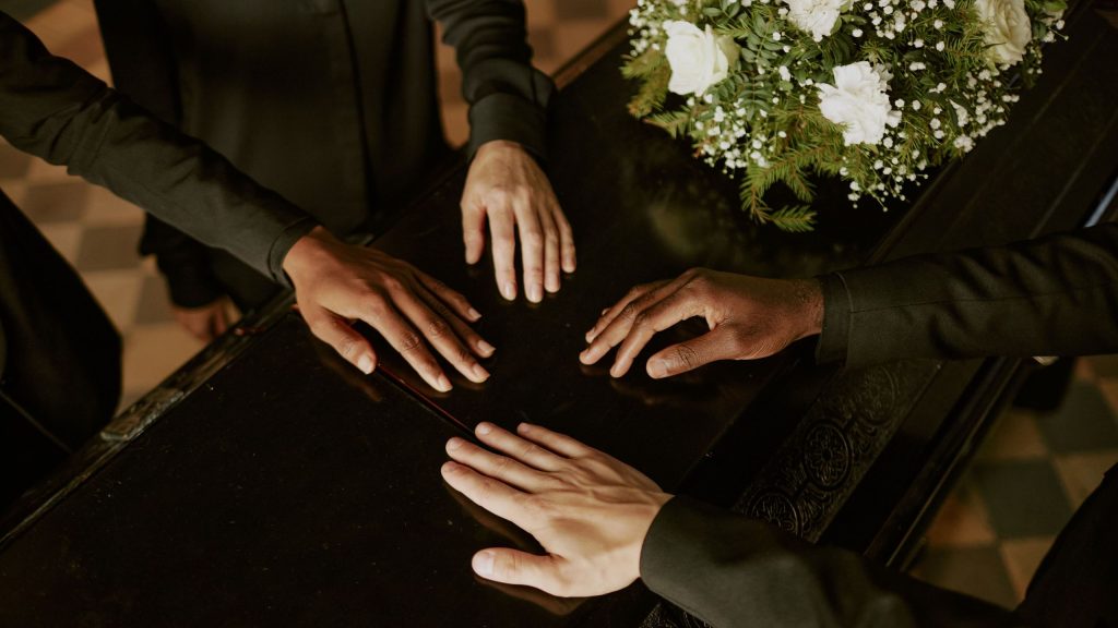 Manos sobre un ataud