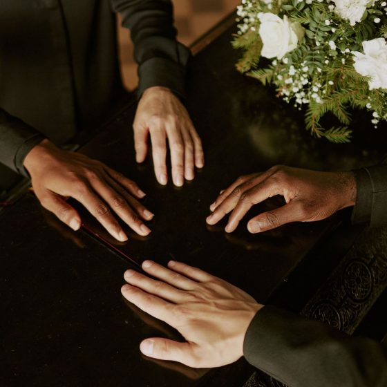 Manos sobre un ataud