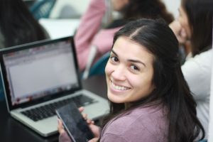 chica sonriente frente al ordenador